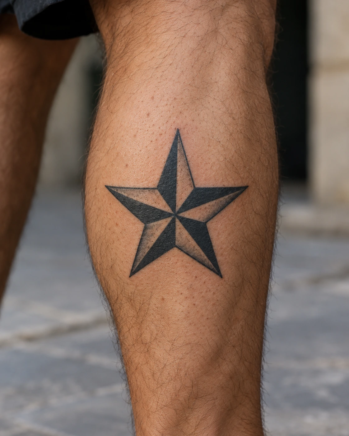 Tatouage étoile : repère, souvenir ou vœu, choisir le bon motif | TATOUEZ Étoile nautique à cinq pointes alternant noir et peau libre sur un mollet.