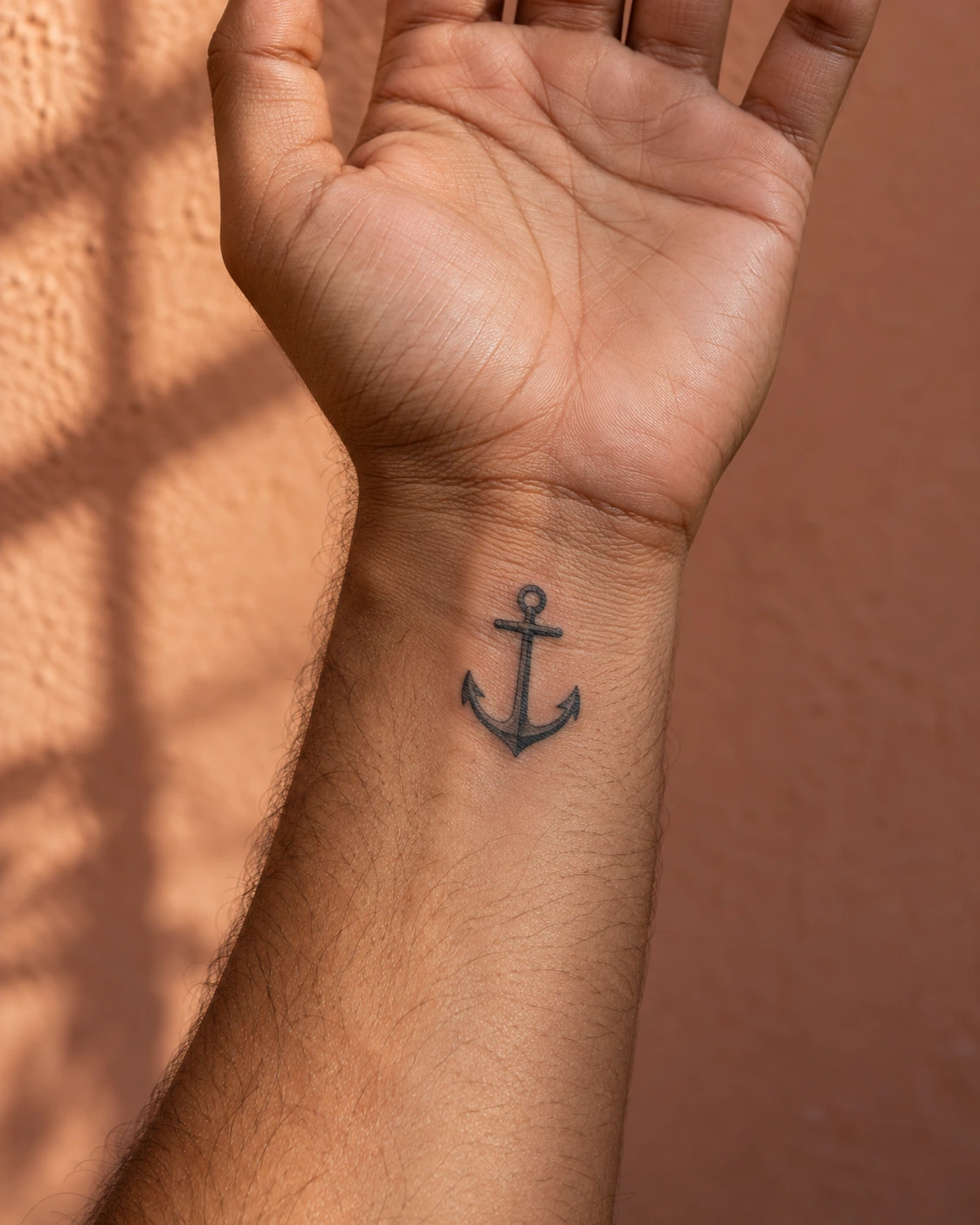 Tatouage ancre : stabilité, attachement et références marines | TATOUEZ Petite ancre noire sur l’intérieur d’un poignet.